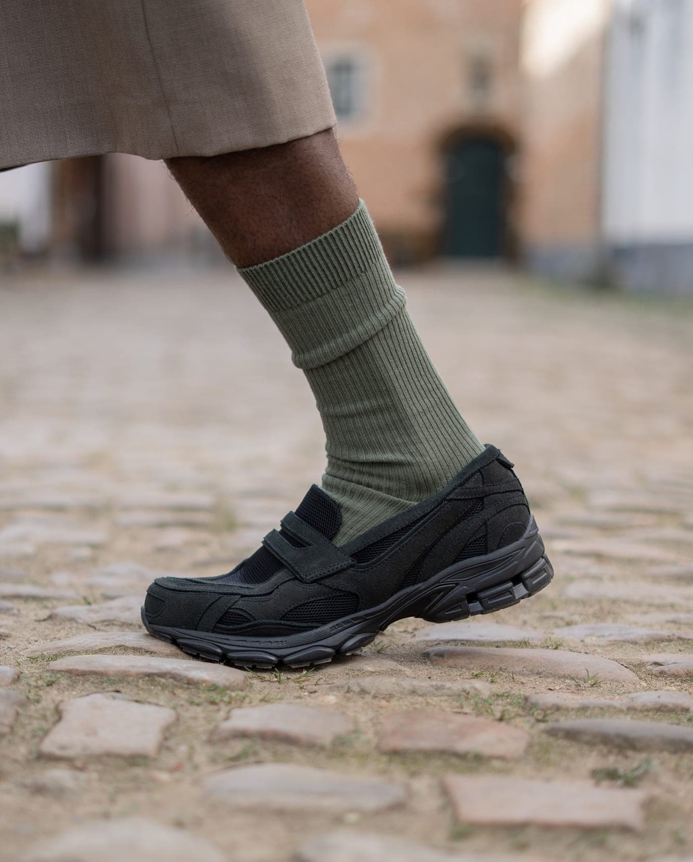 Detail frame: sock and footwear styling on cobblestone